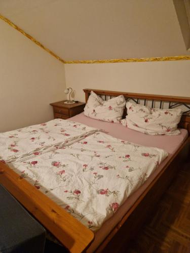 um quarto com uma cama com um edredão e almofadas florais em Ferienwohnung am Stadtrand em Sankt Pölten