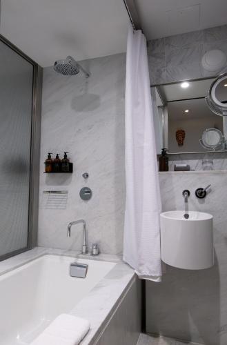 a white bathroom with a tub and a sink at Hotel Alameda, Highline in New York
