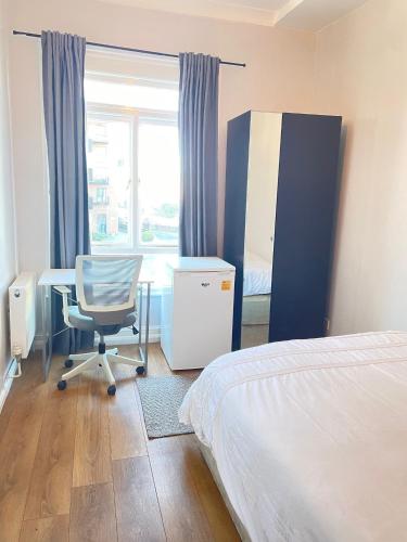 una camera con letto, scrivania e finestra di Dalston's Rooms a Londra