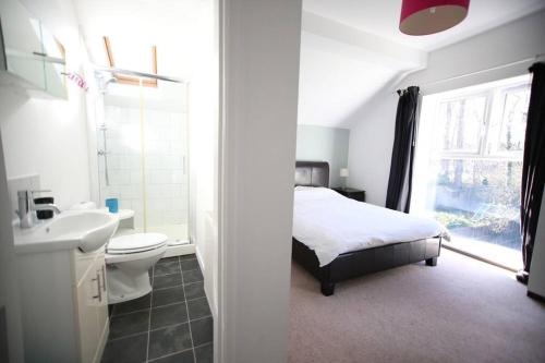 a bedroom with a bed and a sink and a toilet at Spacious and bright 4 bed home in vibrant Chorlton in Manchester