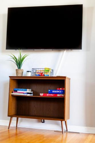 a tv on top of a book shelf with books at Fantastic 3BR Close to Botanical Gardens and Airport in Norfolk
