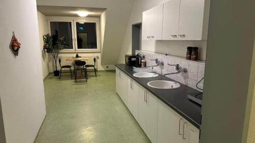 ein Badezimmer mit 2 Waschbecken und einer Theke mit einem Tisch in der Unterkunft Moderne Appartement in Nürnberg
