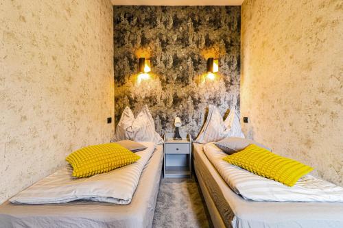 two beds in a room with yellow pillows on them at modrakvillapark in Parłowo