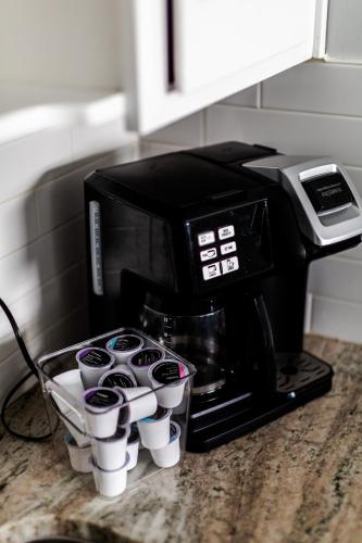a coffee maker sitting on a counter with cups at Fantastic 3BR Close to Botanical Gardens and Airport in Norfolk