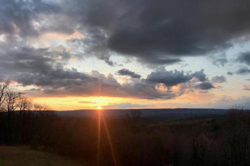 a sunset with the sun setting in the sky at The Retreat at Upland Trail -Private 3BR in Berkeley Springs