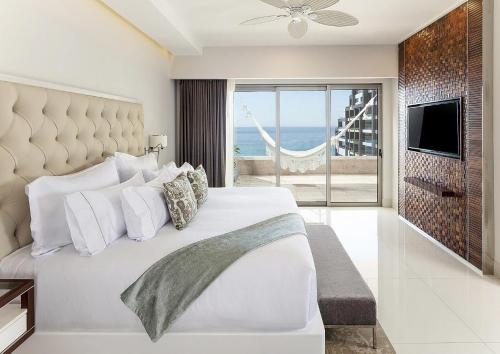 a bedroom with a bed with a view of the ocean at Residential Retreat 1 Bedroom Suite Garza Blanca Resort & Spa in Cabo San Lucas