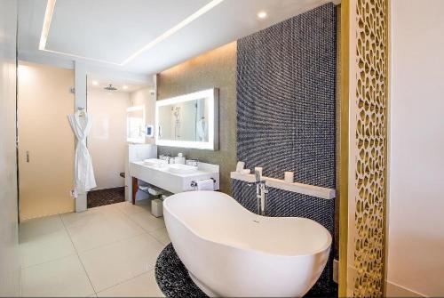 y baño con bañera blanca y lavamanos. en Residential Retreat 1 Bedroom Suite Garza Blanca Resort & Spa, en Cabo San Lucas
