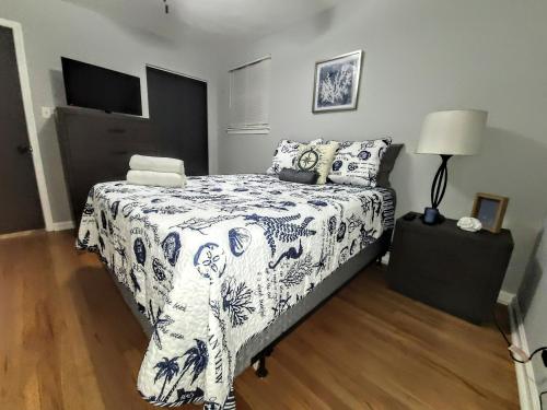 a bedroom with a bed with a black and white comforter at 3-BR Home 3 mins to Airport + 11 mins to Beach in Norfolk
