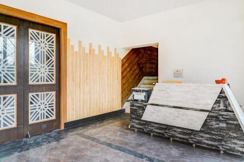um quarto com uma porta de madeira e uma escada em Capital O 66972 Sangam Hotel And Resort em Kotdwāra