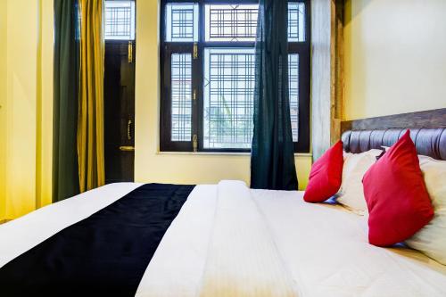 KotdwāraにあるCapital O 66972 Sangam Hotel And Resortのベッドルーム1室(赤と黒の枕が付くベッド1台付)