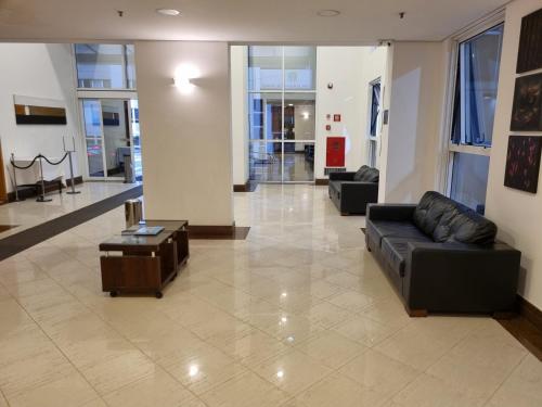 eine Lobby mit einem Sofa und einem Tisch in einem Gebäude in der Unterkunft Apartamento Vista Maravilhosa - Próximo da Paulista in São Paulo