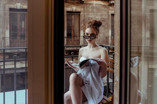 a woman sitting in a window wearing sunglasses at Kondo Maisons in Catania