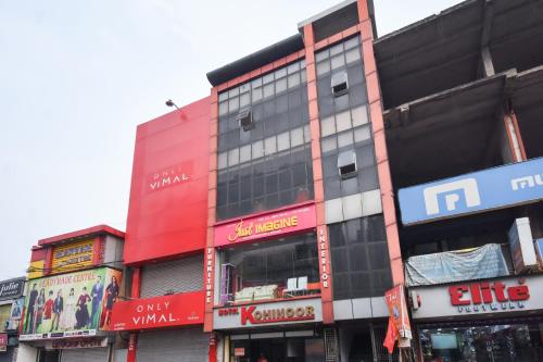 un edificio rojo alto con muchas señales en él en Hotel Kohinoor, en Durgāpur