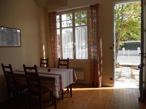 une salle à manger avec une table et des chaises et une fenêtre dans l'établissement Villa proche centre et plage - V04245, à Soulac-sur-Mer