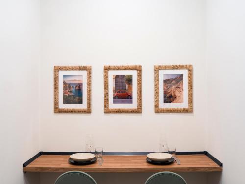 a table with four pictures on a wall at Kondo Maisons in Catania