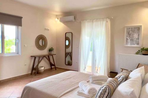 a bedroom with a bed and a mirror and a window at Villa Oinoni in Egina