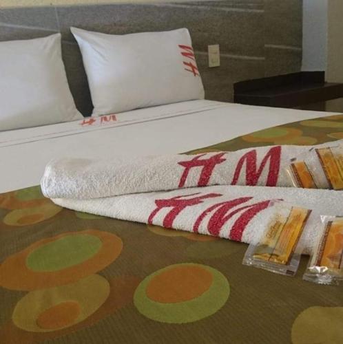 a bed with a white sheets and pillows on it at Hotel Madrid Guadalajara in Guadalajara