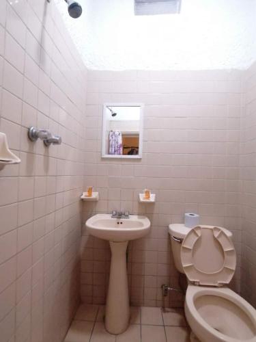 a white bathroom with a toilet and a sink at Hotel Madrid Guadalajara in Guadalajara