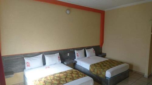 a hotel room with two beds in a room at Hotel Madrid Guadalajara in Guadalajara