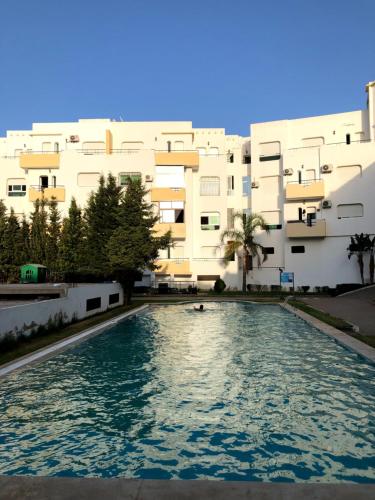 una piscina di fronte a un edificio di Fantastique Appartement avec piscine sur la plage M2 a Tangeri