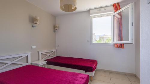une chambre avec deux lits et une fenêtre dans l'établissement MAISONNETTE 6 PERS PROCHE L'ILE ROUSSE, à Belgodère