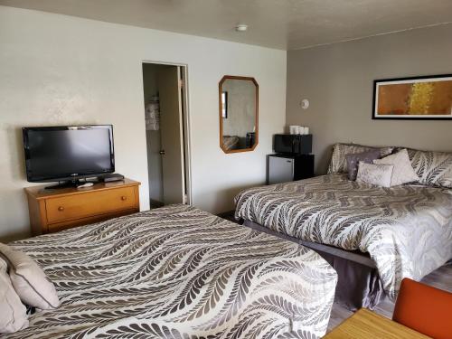 a hotel room with two beds and a flat screen tv at Budget Inn Durango in Durango