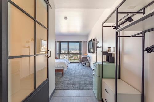 a hallway with a bedroom with a bed and a window at Hotel Koxie in Los Angeles