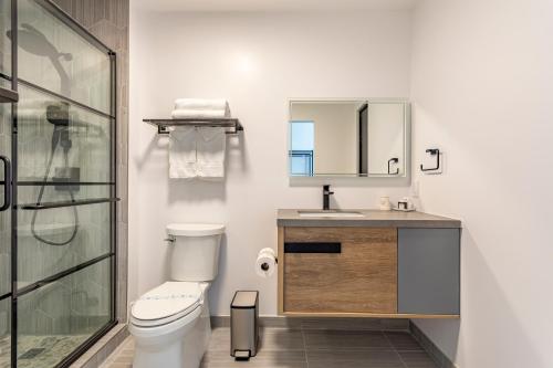 a bathroom with a toilet and a sink and a mirror at Hotel Koxie in Los Angeles