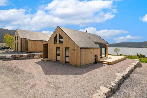 un granero de madera grande con un lago en el fondo en Brattøya sjøstuer, en Kristiansund