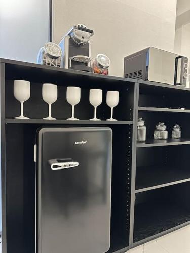 a black refrigerator with wine glasses on a shelf at Cernusco luxury Milanese apartment in Cernusco sul Naviglio