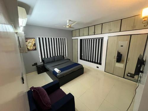 ein kleines Zimmer mit einem Bett und einem Sofa in der Unterkunft Fully Furnished Luxurious Terrace apartment in Pune