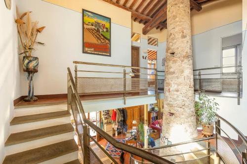 a spiral staircase in a house with a tree at private room with own bathroom at Podere Noceto in Grotti