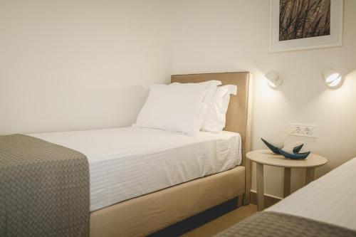 a small bedroom with a bed and a table at Votsalo Tolo in Tolo