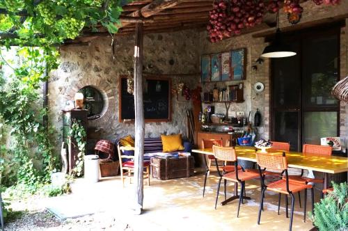 a patio with a wooden table and chairs at private room with own bathroom at Podere Noceto in Grotti