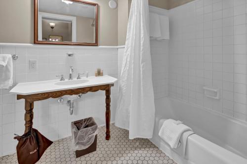 a bathroom with a sink and a bath tub with a mirror at St James Hotel in Red Wing
