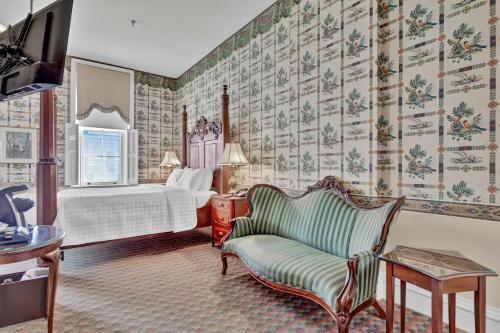 um quarto de hotel com uma cama e uma cadeira em St James Hotel em Red Wing