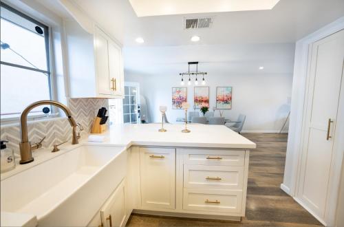a white kitchen with a sink and a window at Beautiful Beverly Hills Townhome in Los Angeles