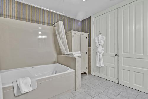 a white bathroom with a bath tub and a sink at St James Hotel in Red Wing