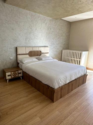 sypialnia z dużym łóżkiem i drewnianą podłogą w obiekcie Prestigia Hay Ryiad Rabat w mieście Rabat