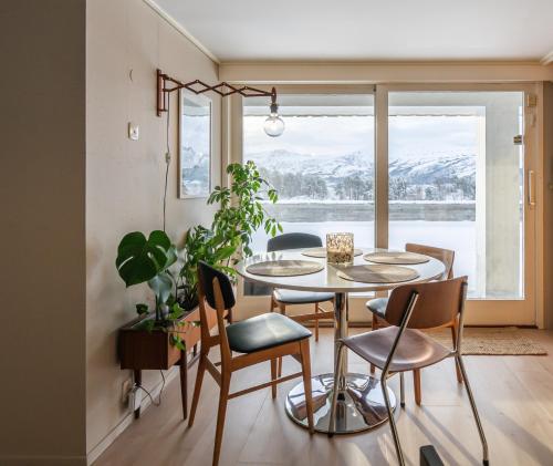een eetkamer met een tafel en stoelen en een raam bij Stunning view apartment in Ålesund with free parking in Ålesund