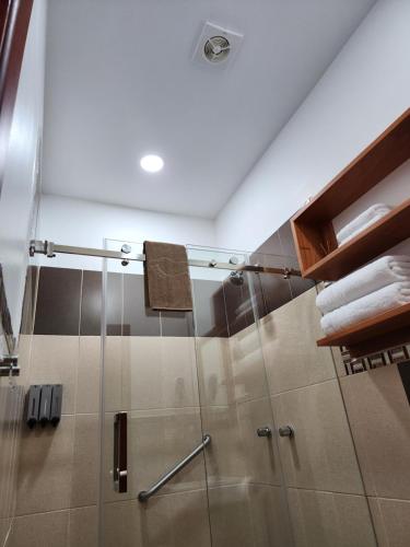 a shower with a glass door in a bathroom at CASA GALAPAGOS by Hostal Fragata in Puerto Ayora