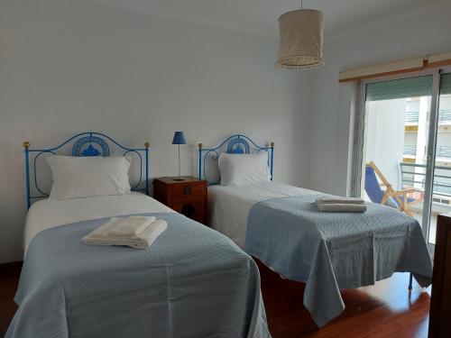 a bedroom with two beds and a window at See to Sea in Ericeira