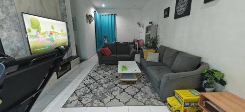een woonkamer met een bank en een tafel bij Damai Kangar Homestay in Kangar
