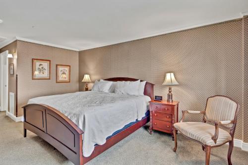 a bedroom with a large bed and a chair at St James Hotel in Red Wing
