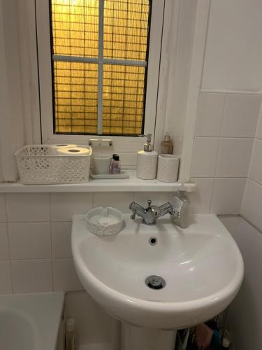 - białą umywalkę w łazience z oknem w obiekcie Double Room close to Central London- Females Only w Londynie