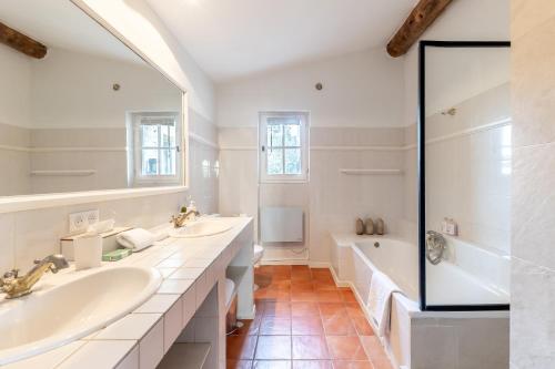 a white bathroom with two sinks and a tub at Mas OREA in Gordes