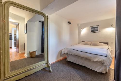 une chambre avec un lit et un grand miroir dans l'établissement Mas OREA, à Gordes
