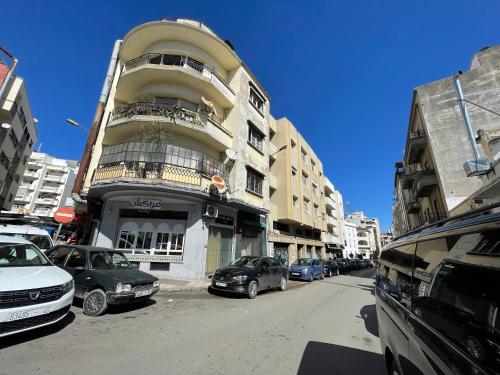 Studio boulevard pasteur central في طنجة: شارع فيه سيارات تقف امام مبنى