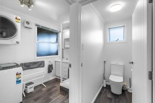 Baño blanco con aseo y lavamanos en Nine Acres en Invercargill