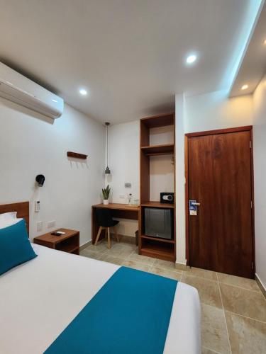 um quarto de hotel com uma cama e uma secretária e uma cama e uma porta em CASA GALAPAGOS by Hostal Fragata em Puerto Ayora